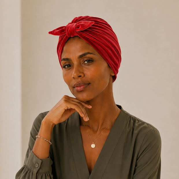 Turban de chimiothérapie rouge en velour avec noeud porté par un mannequin de face